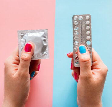 Kondom in der linken Hand und Antibabypille in der rechten Hand