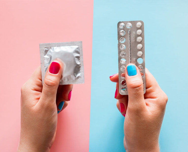 Kondom in der linken Hand und Antibabypille in der rechten Hand