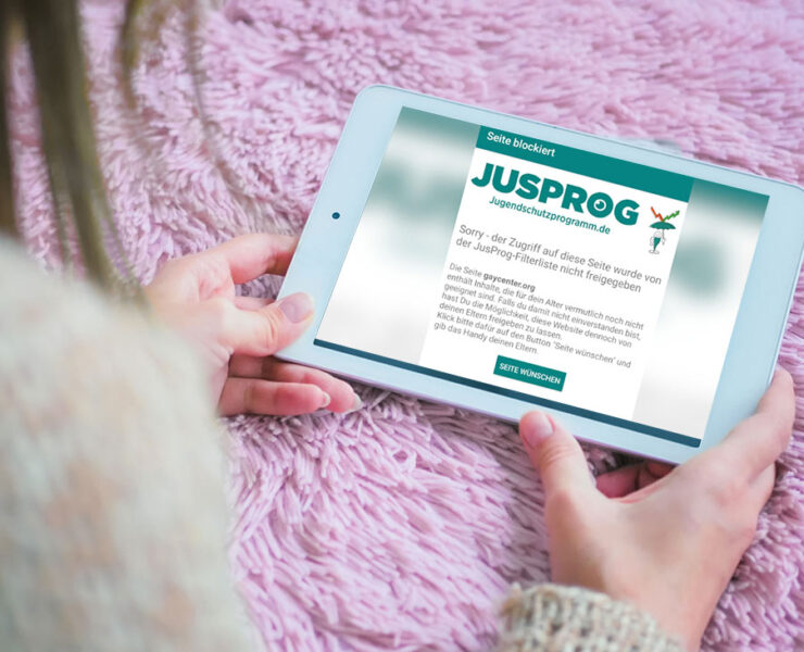 Frau bekommt auf Tablet Jugendschutz Hinweis eingeblendet