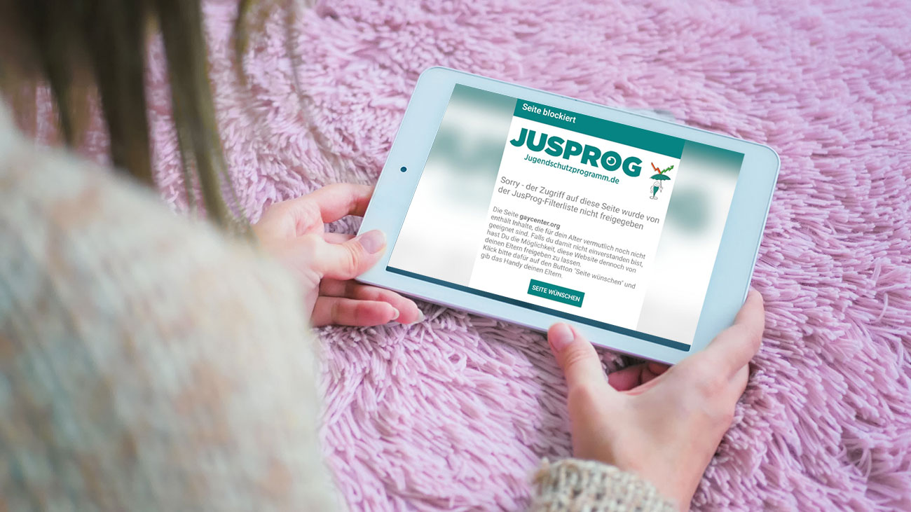 Frau bekommt auf Tablet Jugendschutz Hinweis eingeblendet