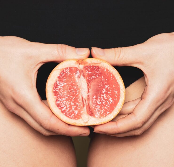 Frau hält Grapefruit als Vagina